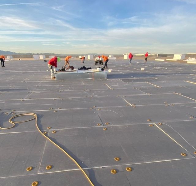 Group of people working on a flat roof